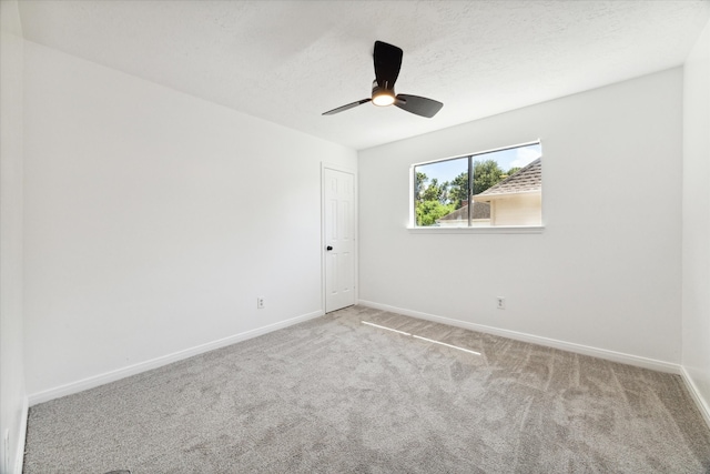 carpeted spare room with ceiling fan and a textured ceiling