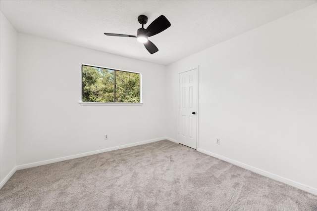 empty room featuring light colored carpet and ceiling fan