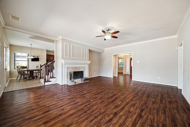 unfurnished living room with wood-type flooring, a premium fireplace, ornamental molding, and ceiling fan