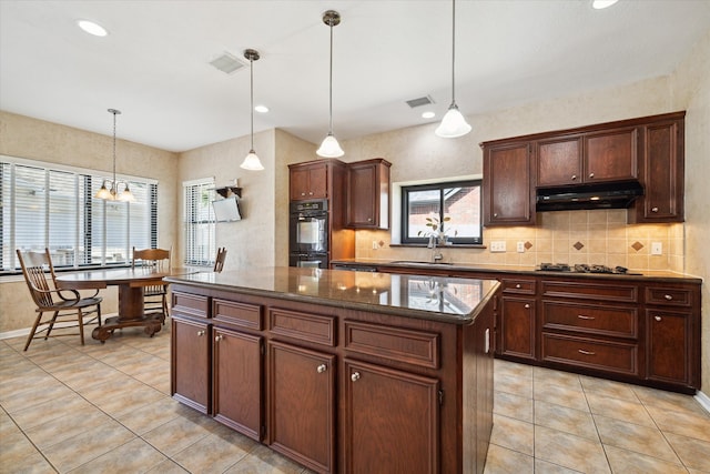 kitchen featuring a kitchen island, black double oven, gas cooktop, hanging light fixtures, and light tile patterned floors