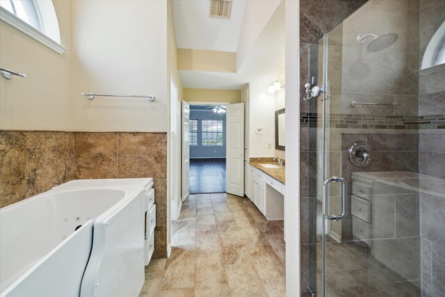 bathroom featuring a wealth of natural light, plus walk in shower, vaulted ceiling, and vanity