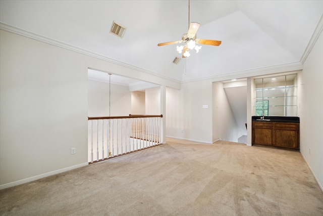 unfurnished room with ceiling fan, ornamental molding, vaulted ceiling, and light carpet