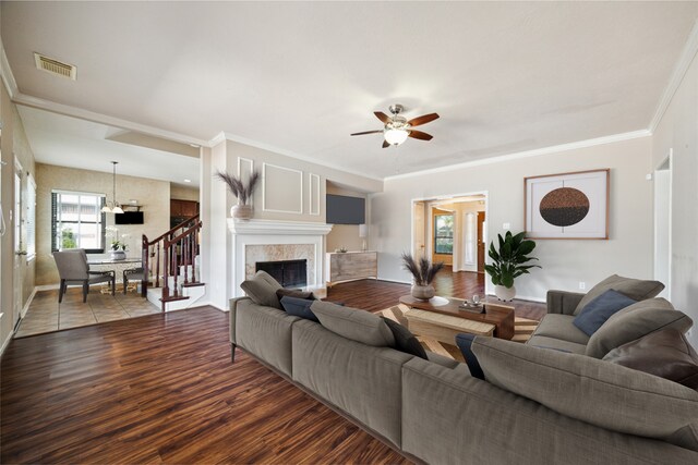 living room featuring hardwood / wood-style flooring, crown molding, and ceiling fan