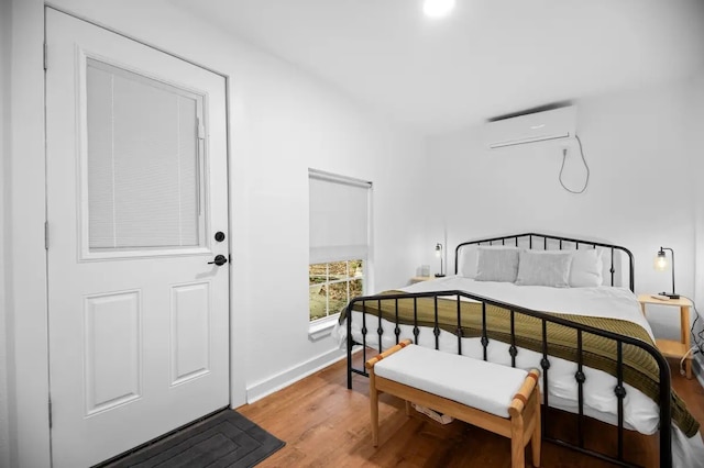 bedroom featuring a wall unit AC and hardwood / wood-style floors