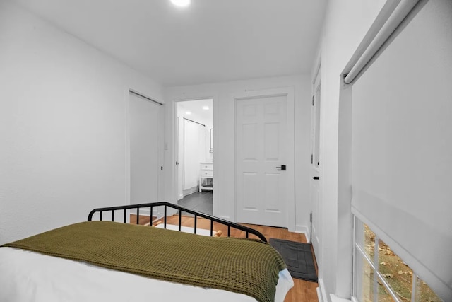 bedroom featuring hardwood / wood-style floors and connected bathroom