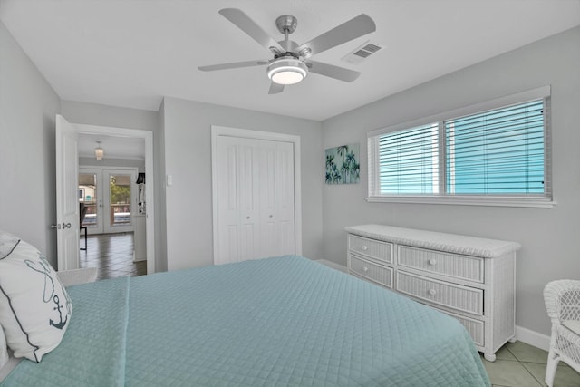 tiled bedroom with french doors, multiple windows, a closet, and ceiling fan