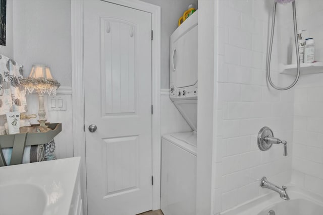 full bathroom with vanity, toilet, stacked washer and dryer, and tiled shower / bath