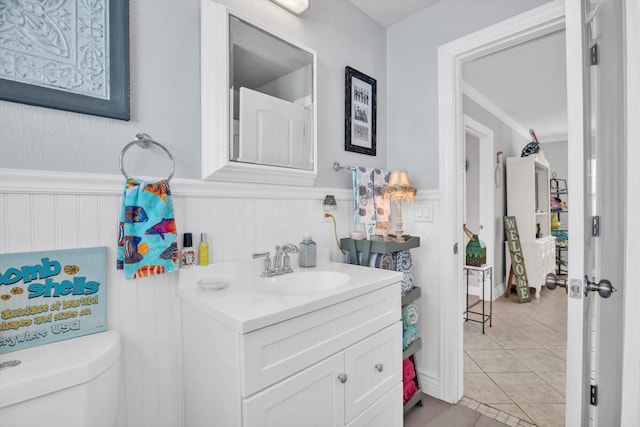 bathroom featuring toilet, crown molding, vanity, and tile patterned floors