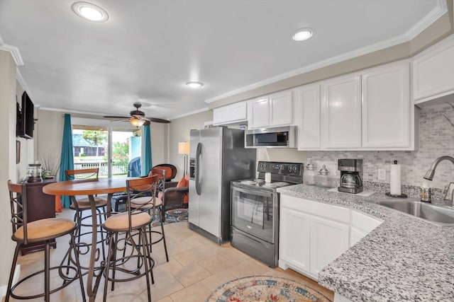 kitchen featuring ornamental molding, white cabinetry, stainless steel appliances, and sink