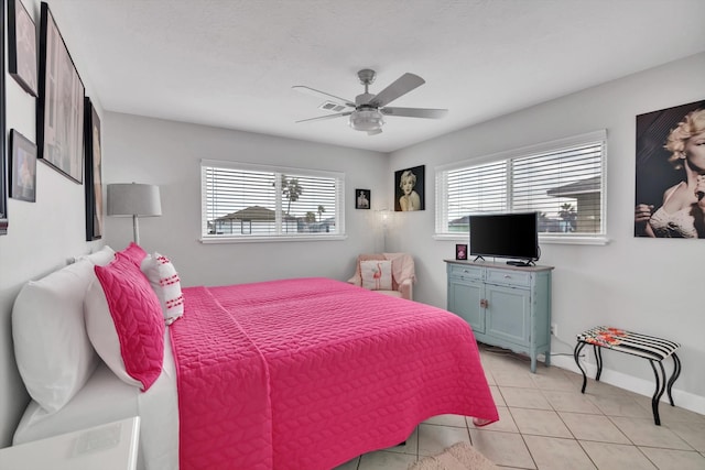 tiled bedroom featuring multiple windows and ceiling fan