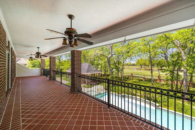 view of patio featuring a fenced in pool and ceiling fan