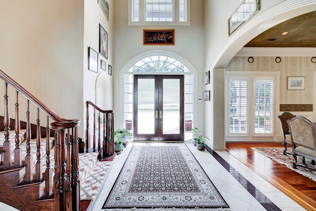 entryway featuring french doors, hardwood / wood-style flooring, plenty of natural light, and a high ceiling