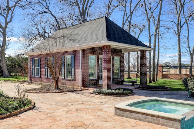 exterior space featuring an in ground hot tub