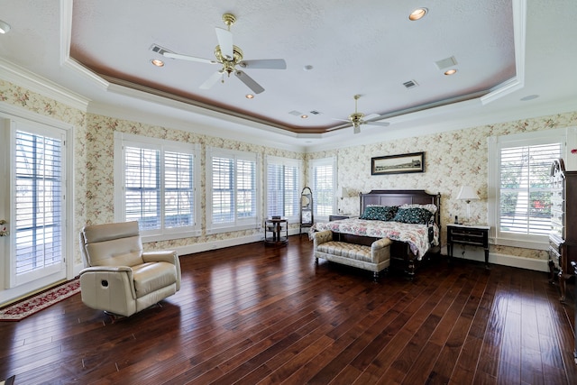 bedroom with ceiling fan, dark wood-type flooring, crown molding, a tray ceiling, and access to exterior