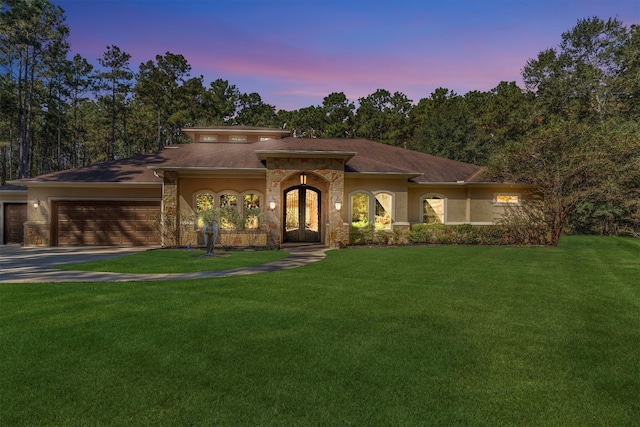 view of front of property with a yard and a garage