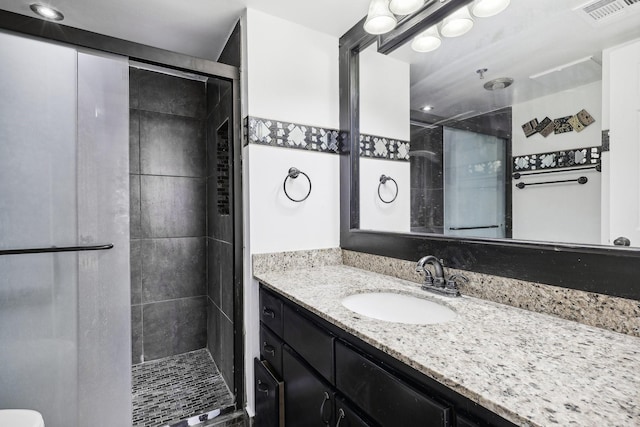 bathroom with vanity and a shower with shower door