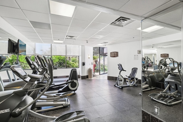 gym featuring floor to ceiling windows and a drop ceiling