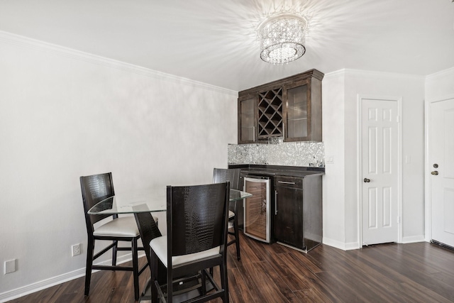 dining space featuring baseboards, dark wood finished floors, wine cooler, wet bar, and crown molding