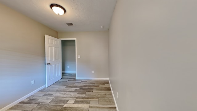 unfurnished room featuring a textured ceiling