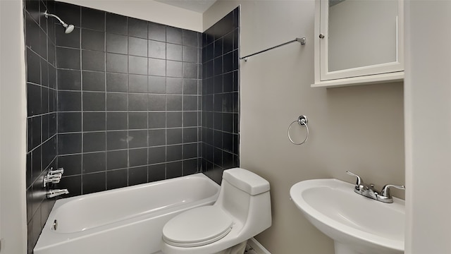 full bathroom with sink, tiled shower / bath combo, and toilet