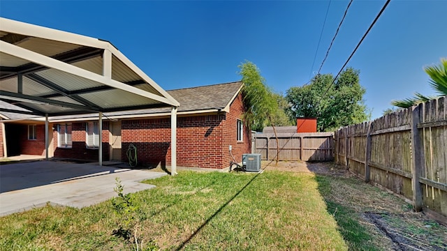 view of yard with central air condition unit and a patio