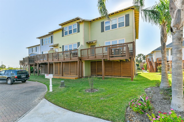 rear view of property featuring a yard and a deck