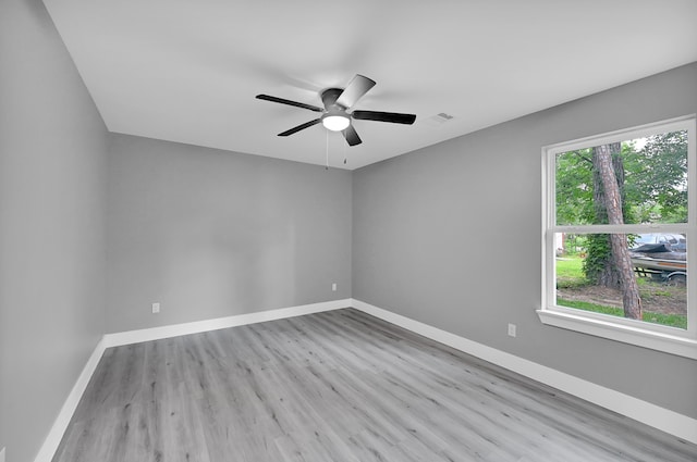 empty room with ceiling fan, light hardwood / wood-style flooring, and plenty of natural light