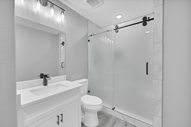 bathroom featuring vanity, toilet, an enclosed shower, and hardwood / wood-style flooring