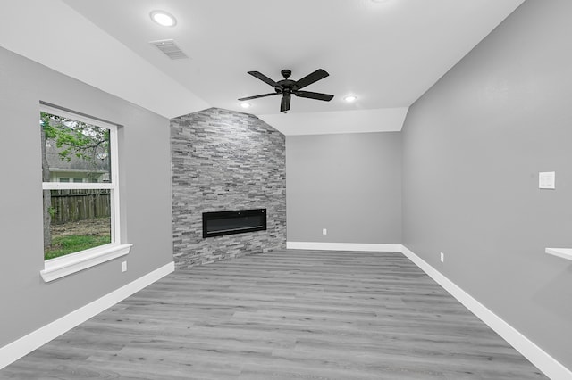 unfurnished living room with ceiling fan, lofted ceiling, light wood-type flooring, and a healthy amount of sunlight