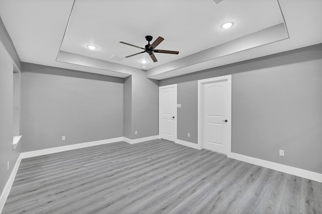 interior space featuring a tray ceiling, light hardwood / wood-style flooring, and ceiling fan