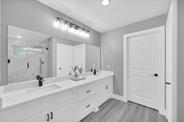 bathroom with an enclosed shower, wood-type flooring, and vanity