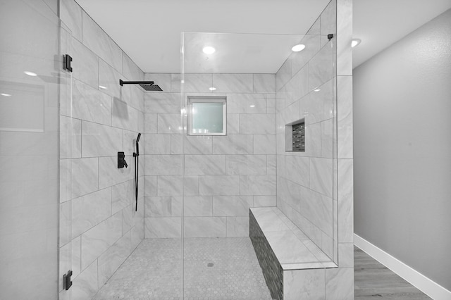 bathroom featuring wood-type flooring and a shower with shower door