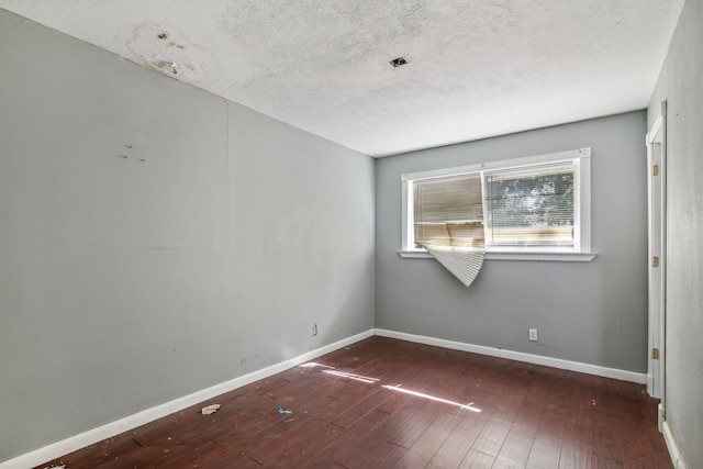 unfurnished room featuring dark hardwood / wood-style floors and a textured ceiling