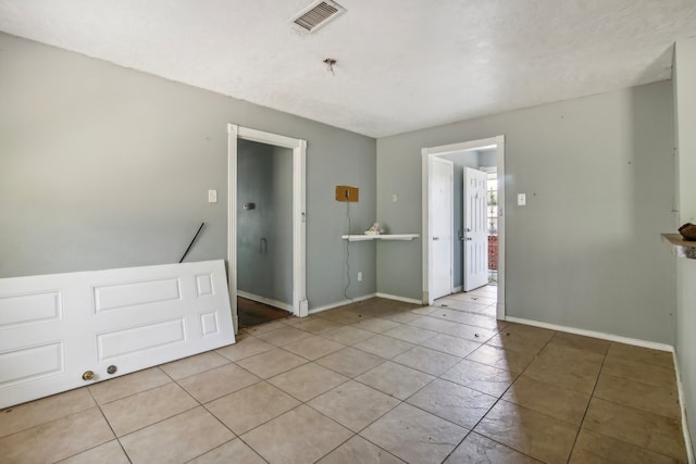 unfurnished room featuring light tile patterned flooring