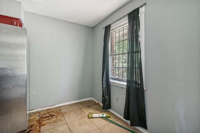 doorway with light tile patterned flooring and a textured ceiling