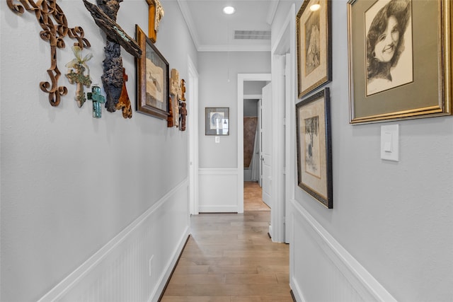 hallway featuring ornamental molding and hardwood / wood-style flooring
