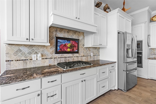 kitchen featuring light wood-type flooring, tasteful backsplash, ornamental molding, white cabinets, and appliances with stainless steel finishes