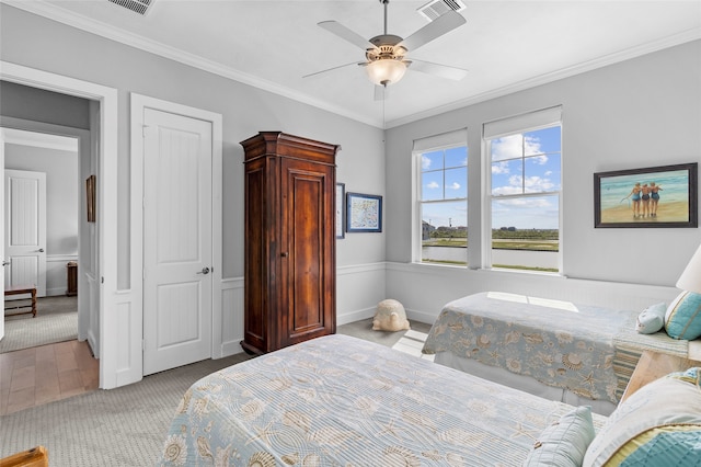 carpeted bedroom with ornamental molding and ceiling fan