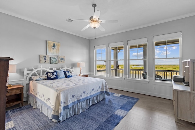 bedroom with ceiling fan, crown molding, and dark wood-type flooring