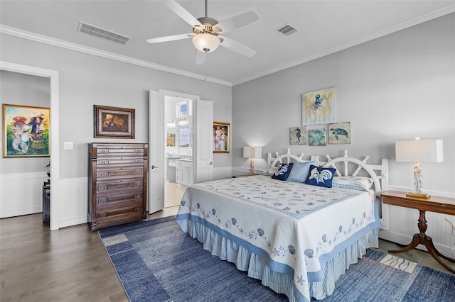 bedroom with ceiling fan, connected bathroom, dark wood-type flooring, and crown molding