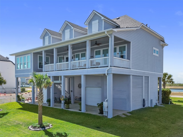 exterior space with ceiling fan, a balcony, a lawn, and a patio area