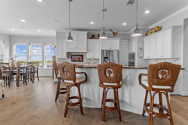 9 Hawkeye, Hitchcock, TX 77563 - kitchen with stainless steel appliances, healthy amount of natural light, white cabinets, recessed lighting, and dark stone counters