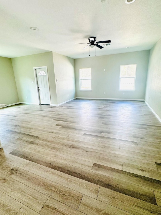 spare room featuring a textured ceiling, light hardwood / wood-style flooring, and ceiling fan