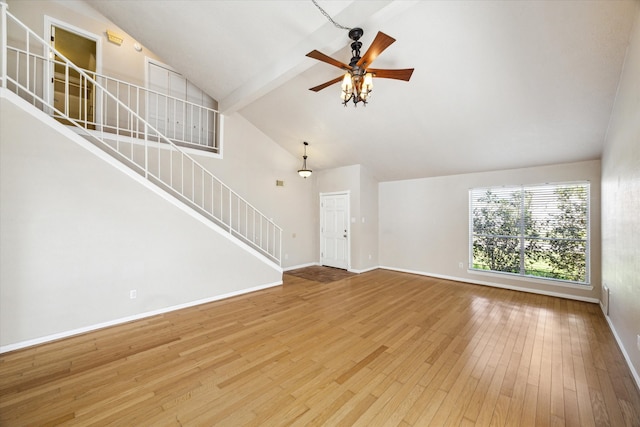 unfurnished living room with ceiling fan, beamed ceiling, wood-type flooring, and high vaulted ceiling