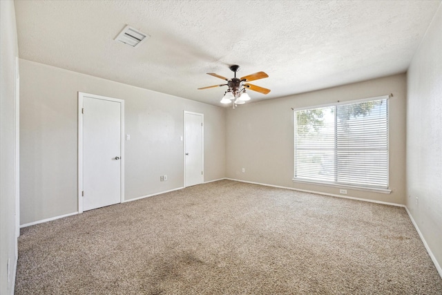 unfurnished room with ceiling fan, a textured ceiling, and carpet flooring