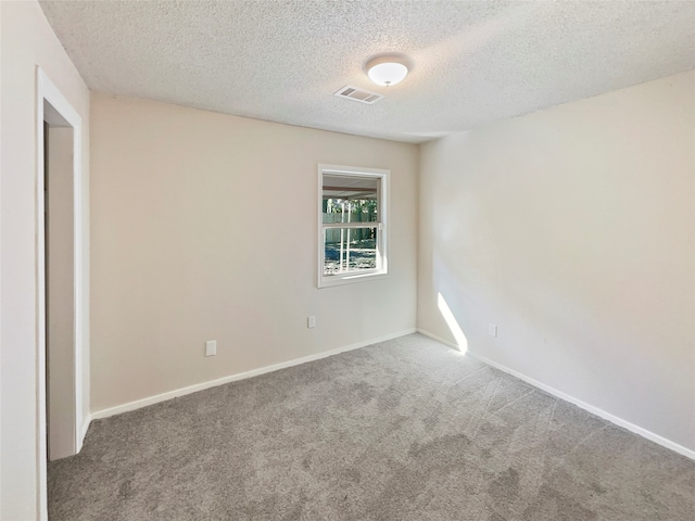 carpeted empty room with a textured ceiling