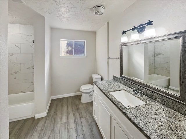 bathroom with a textured ceiling, hardwood / wood-style floors, vanity, and toilet