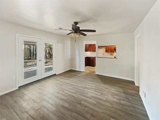 empty room with french doors, light hardwood / wood-style floors, and ceiling fan