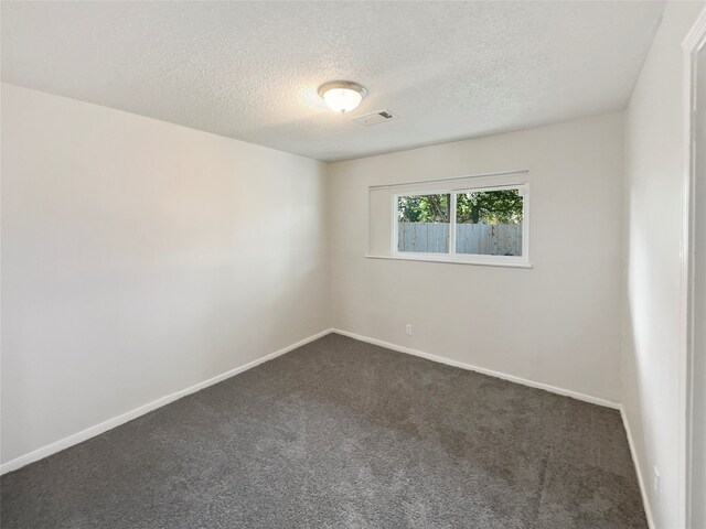 carpeted spare room featuring a textured ceiling