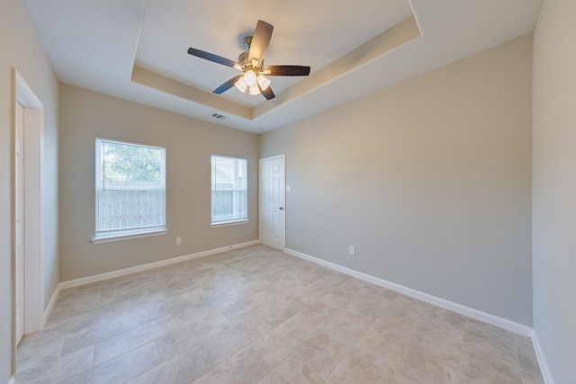 unfurnished room featuring a tray ceiling and ceiling fan